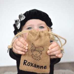 Kind met zwarte baret toont juten cadeauzakje met Zeeuwse meisje en naam Roxanne
