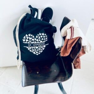 Donkerblauwe katoenen tasje met Rozenburg hartmotief op vintage stoel met kleding