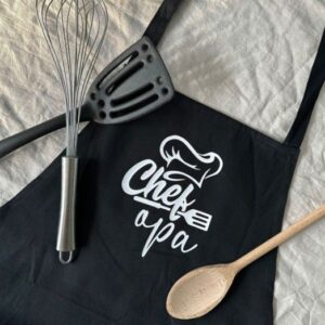 Zwart keukenschort met tekst Chef à pa en kookgerei, origineel vaderdagcadeau uit Zeeland cadeauwinkel