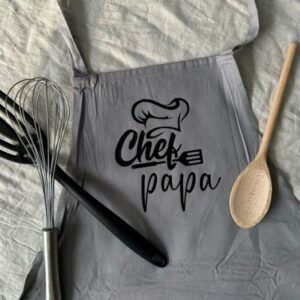 Grijze keukenschort met opdruk Chef papa en houten kookgerei als vaderdagcadeau