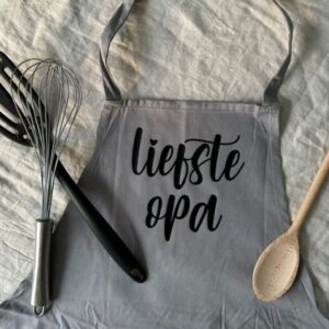 Grijs keukenschort met tekst 'liefste opa' en kookgerei, origineel cadeau voor opa