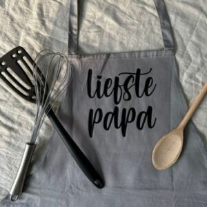 Grijze keukenschort met tekst 'liefste papa' en houten lepel, garde en spatel - origineel cadeau voor vader