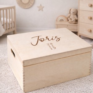 Houten herinneringskist met naam Joris en geboortedatum gegraveerd in babykamer met knuffels