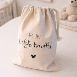 Katoenen trekkoord zakje met tekst 'Mijn liefste knuffel' op babykamer commode met teddybeer