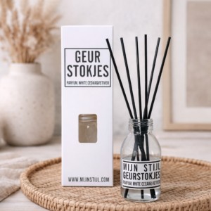 Geurstokjes white cedar vetiver op rieten dienblad met verpakking in natuurlijke woonkamer setting
