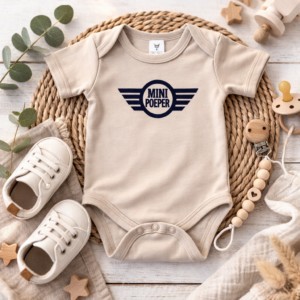Beige baby romper met 'Mini Poeper' opdruk op rieten placemat met houten speelgoed en schoentjes