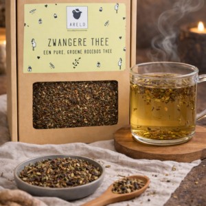 Zwangere thee van Arelo met groene rooibos, verse theeglas en losse kruiden op linnen doek met kaarslicht