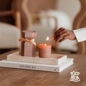 Hand steekt geurkaars aan naast luxe diffuser op dienblad, perfecte cadeau-ideeën voor ontspanning