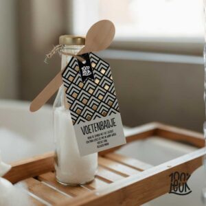 Voetenbadzout in glazen flesje met houten lepel op bamboe dienblad, origineel cadeau uit Zeeland